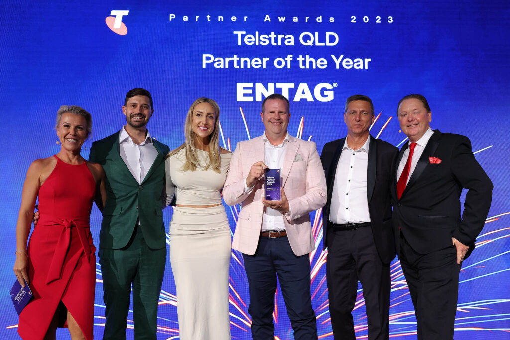 Entag team receiving Telstra QLD Partner of the Year trophy from top Telstra executives.